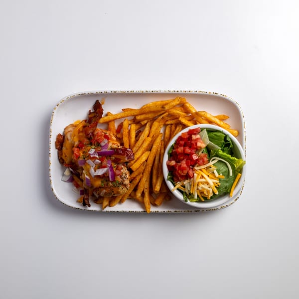 Chicken with melted cheese, bacon, and diced vegetables, served with fries and a side salad.